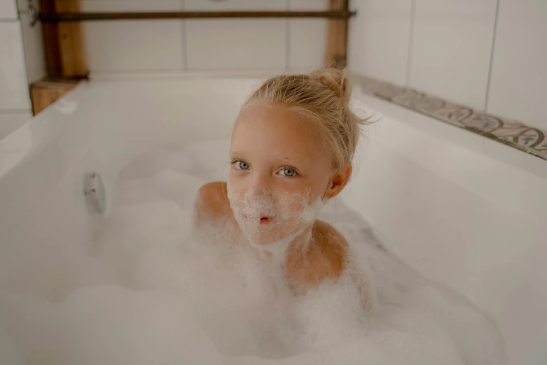 a little girl taking a bubble bath in a bathtub, by Emma Andijewska, pexels contest winner, lovingly looking at camera, manuka, gif, hot tub