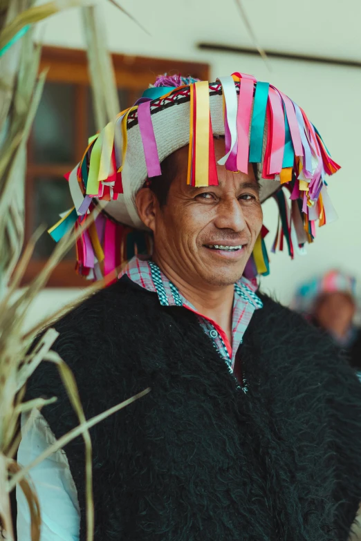 a man wearing a colorful hat on top of his head, traditional dress, cheeky smile, multiple stories, slide show