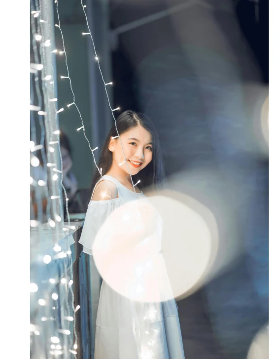 a woman standing in front of a string of lights, by Tan Ting-pho, pexels contest winner, light and space, white dress!! of silver hair, 🤤 girl portrait, pastel', 15081959 21121991 01012000 4k