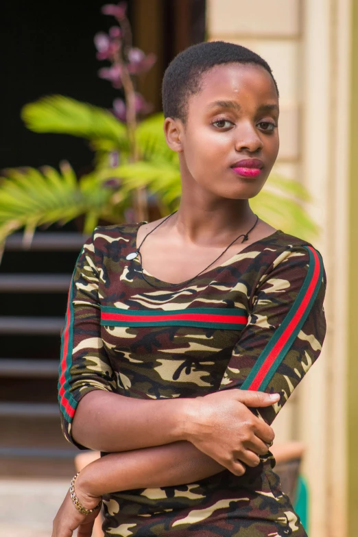 a woman standing in front of a building, by Ella Guru, wearing camo, black teenage girl, wearing stripe shirt, smooth details