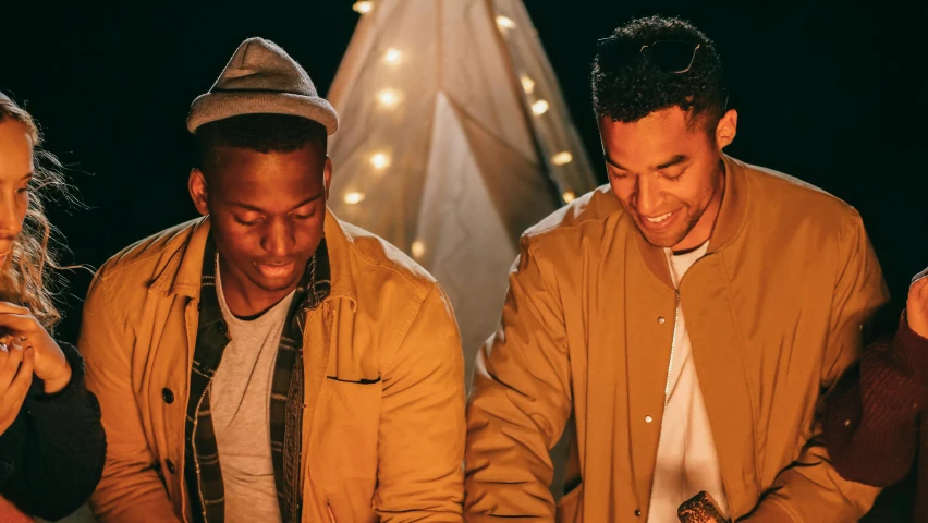 a group of people standing around a cake, outdoors at night, outlive streetwear collection, two men hugging, brown