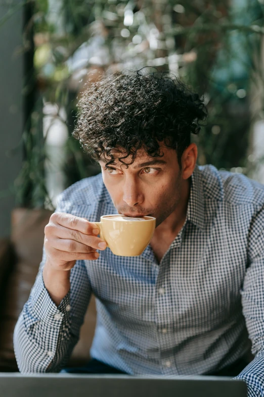 a man sitting in front of a laptop drinking a cup of coffee, a portrait, by Adam Dario Keel, pexels contest winner, renaissance, curly middle part haircut, middle eastern, gif, mid-shot of a hunky