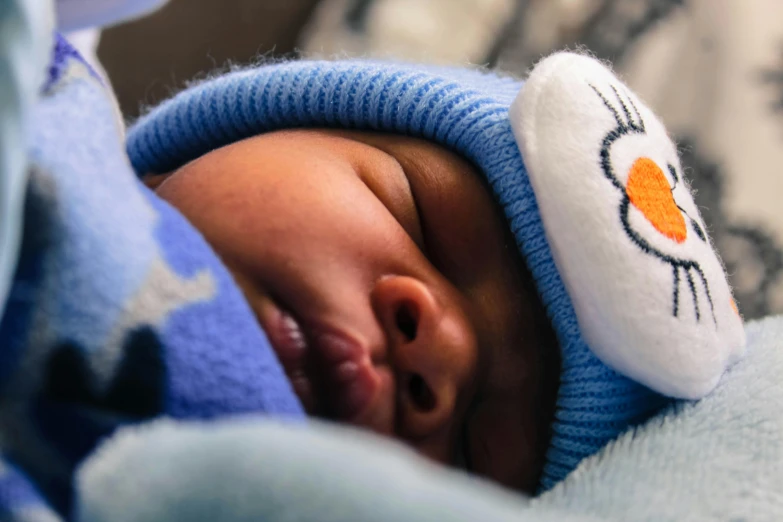 a close up of a baby wearing a hat, by Carey Morris, pexels contest winner, symbolism, donald duck in real life, goodnight, blue themed, avatar image