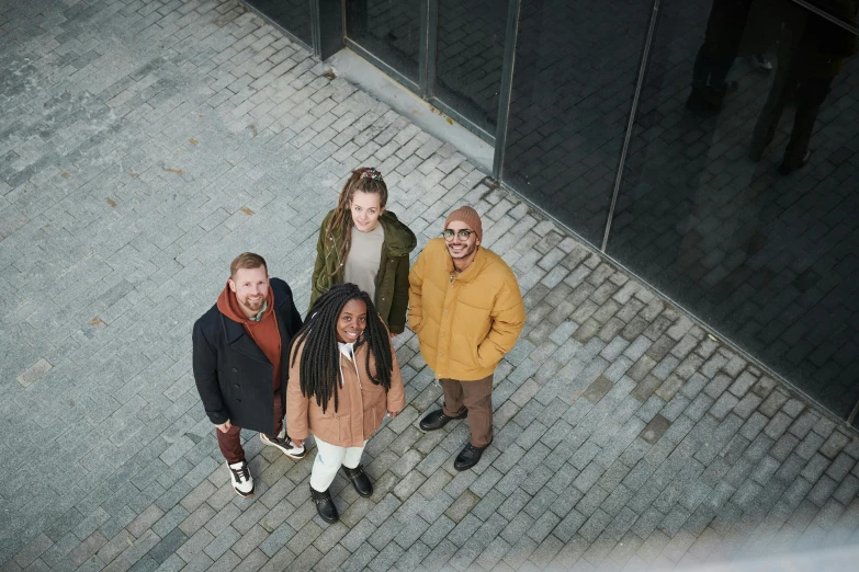 a group of people standing next to each other, ochre, overhead photography, portrait image, four stories high