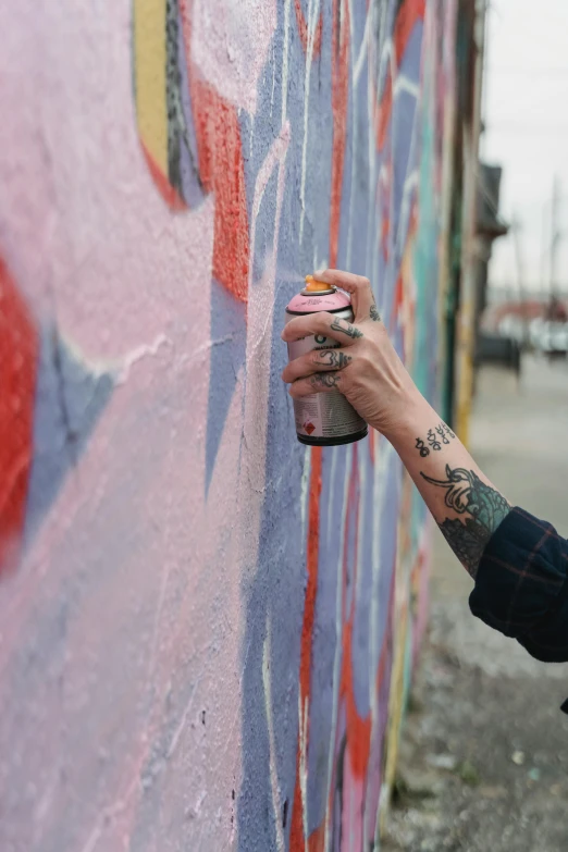 a man spray painting graffiti on a wall, inspired by Okuda Gensō, trending on pexels, lil peep, portra 8 0 0 ”, photograph of a sleeve tattoo, woman