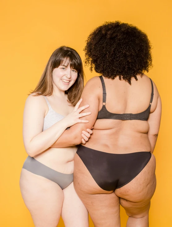 a couple of women standing next to each other, by Arabella Rankin, buttshape, thick set features, supportive, gray skin