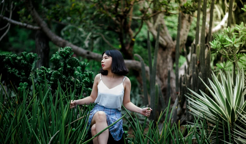 a woman sitting in a field of tall grass, a portrait, inspired by helen huang, pexels contest winner, in a tropical forest, wearing a tanktop and skirt, avatar image, sydney park