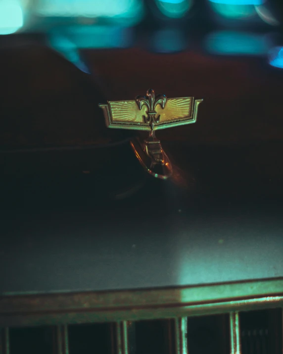 a close up of a hood ornament on a car, an album cover, inspired by Elsa Bleda, unsplash, holography, wings spread, low quality photo, indoor shot, historical photo