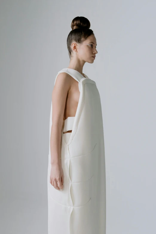 a woman standing in a white dress, inspired by Kuno Veeber, smart textiles, looking her shoulder, soft texture, minimal structure