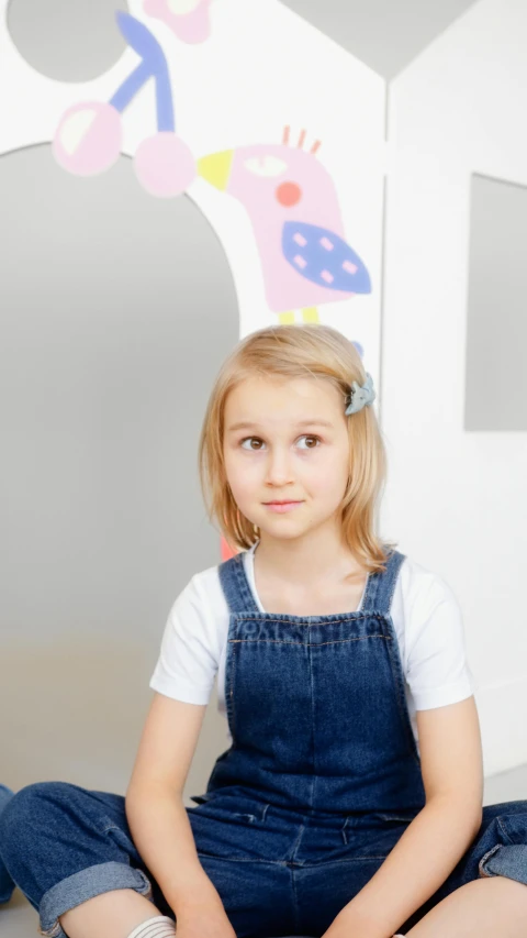 a little girl sitting on the floor in front of a doll house, a picture, pexels, wearing blue jean overalls, 15081959 21121991 01012000 4k, portrait of nordic girl, looking her shoulder