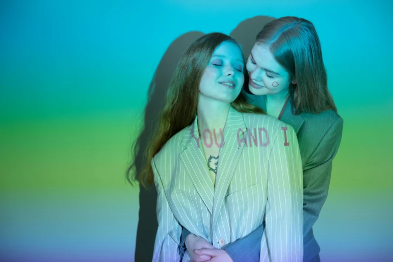 a couple of women standing next to each other, inspired by Elsa Bleda, trending on pexels, holography, rainbow stripe backdrop, sadie sink, lesbian embrace, showstudio