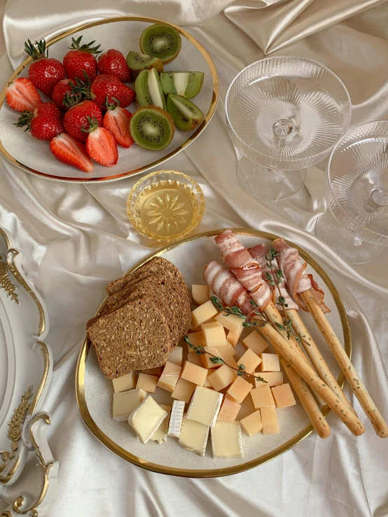 a close up of a plate of food on a table, champagne on the table, cheese and salami on the table, 🐿🍸🍋, gold