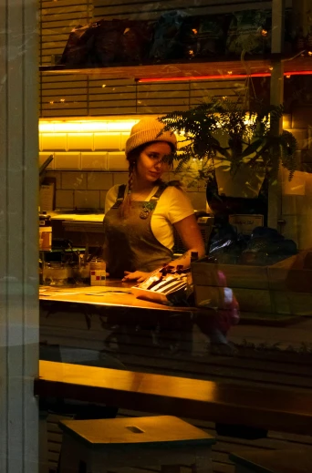 a woman that is standing in front of a window, inspired by Nan Goldin, process art, at the counter, chef table, backlit!!, aussie baristas