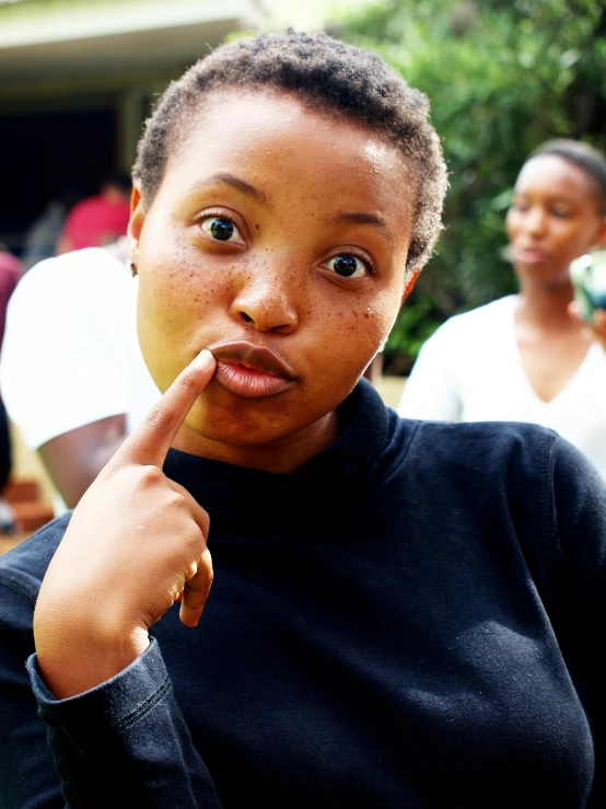 a woman with a finger on her lips, trending on unsplash, happening, very kenyan, bruh moment, shaven face, college