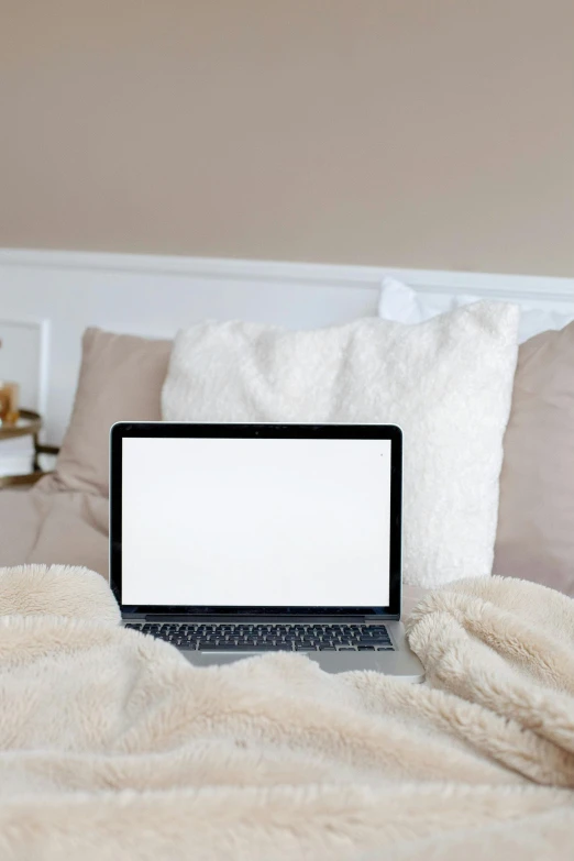 a laptop computer sitting on top of a bed, by Carey Morris, pexels, light beige pillows, white panels, computer, rectangle