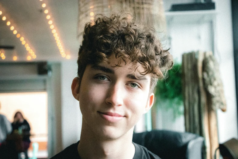 a close up of a person wearing a black shirt, inspired by John Luke, pexels contest winner, he has short curly brown hair, discord profile picture, adam ondra, ignant