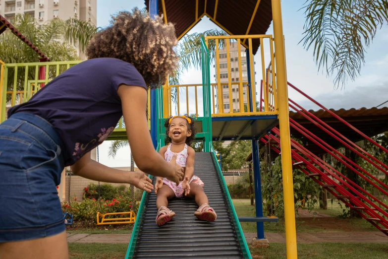 a woman standing next to a little girl on a slide, by Felipe Seade, pexels contest winner, park in background, avatar image, brazilian, thumbnail