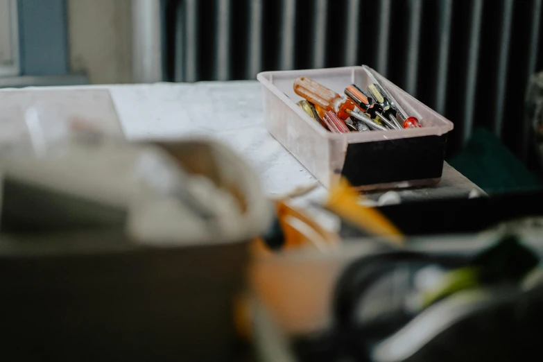 a box sitting on top of a table next to a window, a charcoal drawing, trending on pexels, tools and junk on the ground, background image, markers, maintenance photo