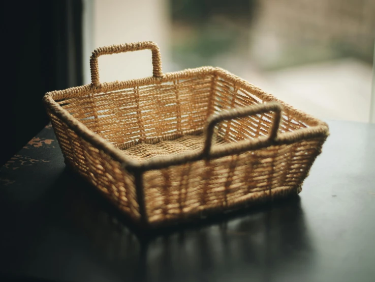 a wicker basket sitting on top of a table, unsplash, carrying a tray, rectangle, bathed in golden light, utility