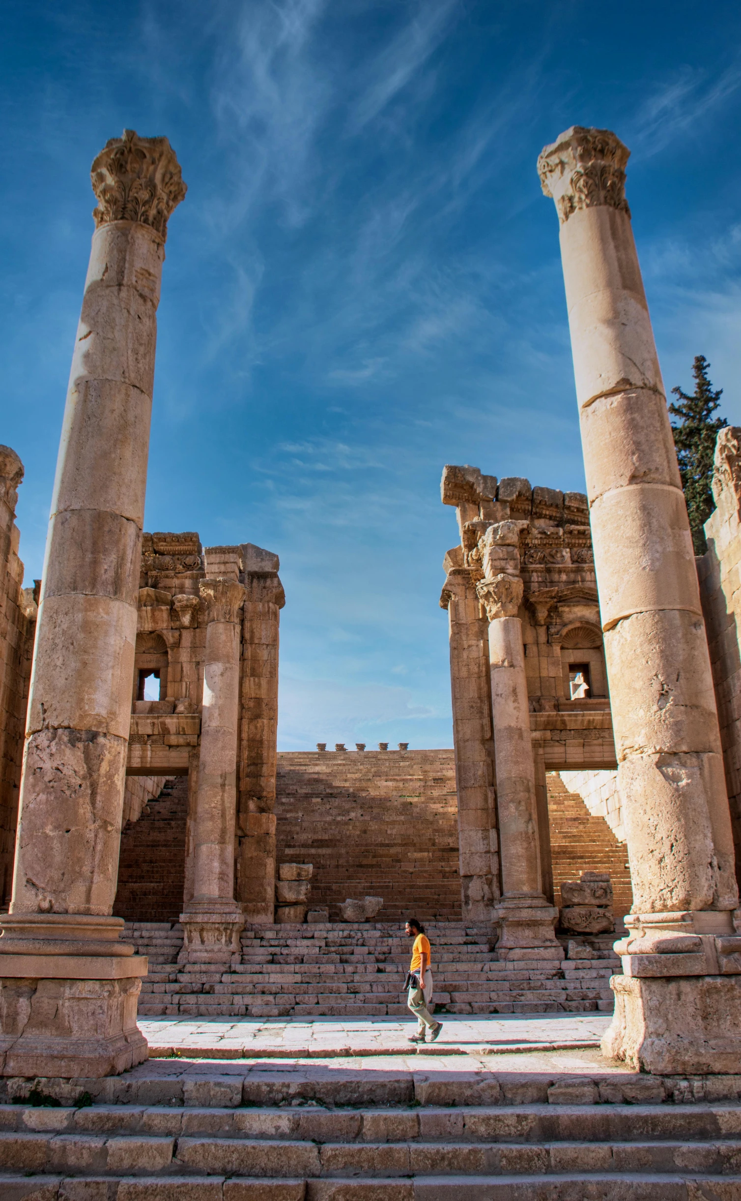 a person is walking through the ruins of a building, pexels contest winner, neoclassicism, wide panoramic shot, jordan, square, vivid colours