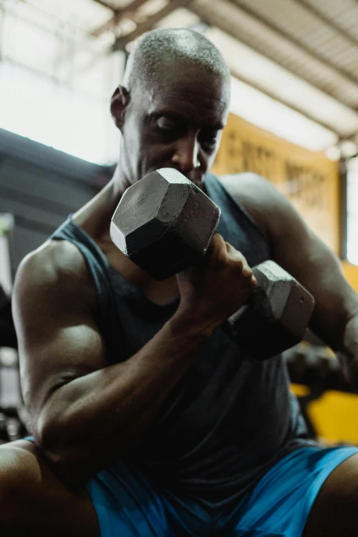 a man lifting a dumbbell in a gym, pexels contest winner, man is with black skin, unedited, magnesium, stacked