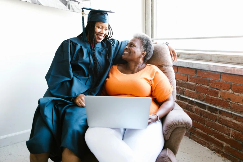 a couple of women sitting next to each other on a couch, pexels contest winner, renaissance, graduation photo, in front of a computer, wearing an academic gown, african american woman