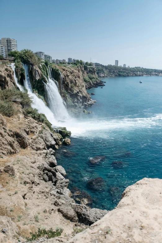 a man standing on top of a cliff next to a body of water, lebanon kirsten dunst, featuring flowing fountains, today\'s featured photograph 4k, whale fall