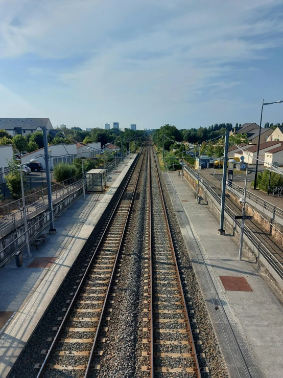 a train traveling down train tracks next to houses, thumbnail, station, symmetrical image, no text