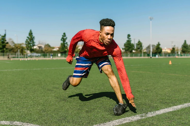 a man is running on a soccer field, pexels contest winner, athletic crossfit build, red and blue garments, thumbnail, 1 2 9 7