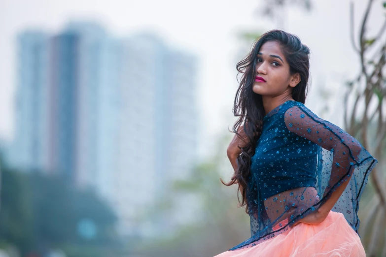 a beautiful young woman posing for a picture, by Max Dauthendey, pexels contest winner, dressed in long fluent skirt, jayison devadas, blue and orange tones, background blur bokeh!!