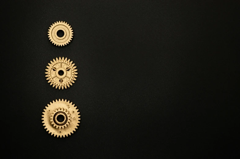 a number of gears on a black surface, an album cover, unsplash, minimalism, gold plated, 3 heads, product introduction photo