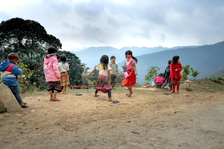 a group of children standing on top of a dirt field, playing games, traditional clothing, landslides, taken in 2 0 2 0