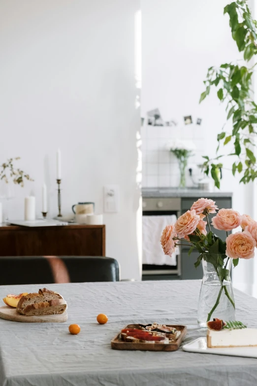 a table that has a bunch of food on it, inspired by Constantin Hansen, unsplash contest winner, minimalism, flowers in foreground, in the kitchen, city apartment cozy calm, minimal pink palette