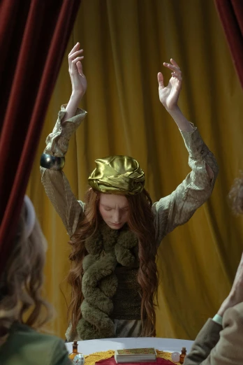a woman sitting at a table with a crown on top of her head, trending on pexels, renaissance, theater dance scene, karen gillan, with yellow cloths, botticelli style