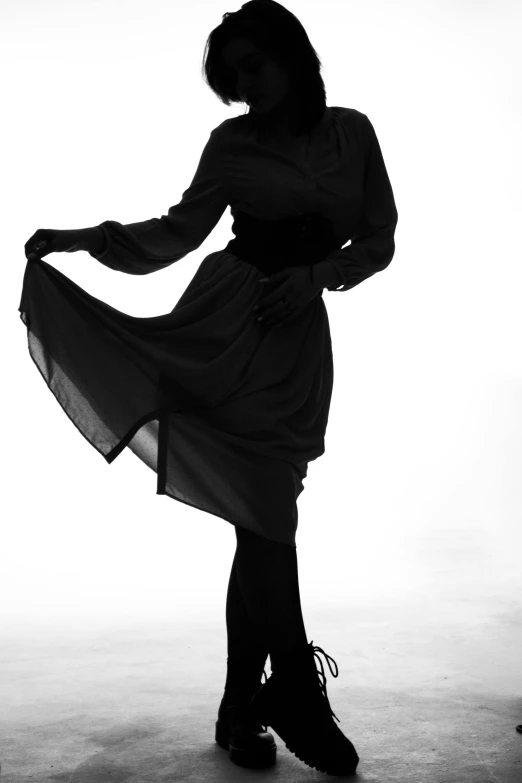 a black and white photo of a woman in a dress, an album cover, by Clifford Ross, unsplash, black oversized clothes, beautiful burqa's woman, pinup pose, full body!! dynamic pose
