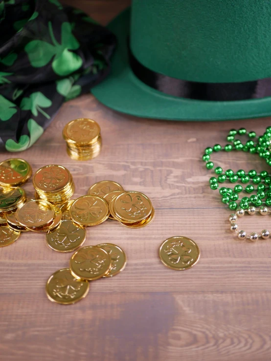 a green hat sitting on top of a wooden table, gold coins, gold decorations, photograph, february)