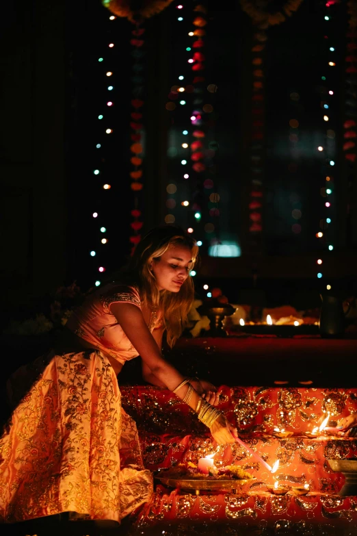 a couple of women sitting on top of a bed, by Alice Mason, pexels contest winner, floating candles, hindu aesthetic, in a glowing skirt, partylights