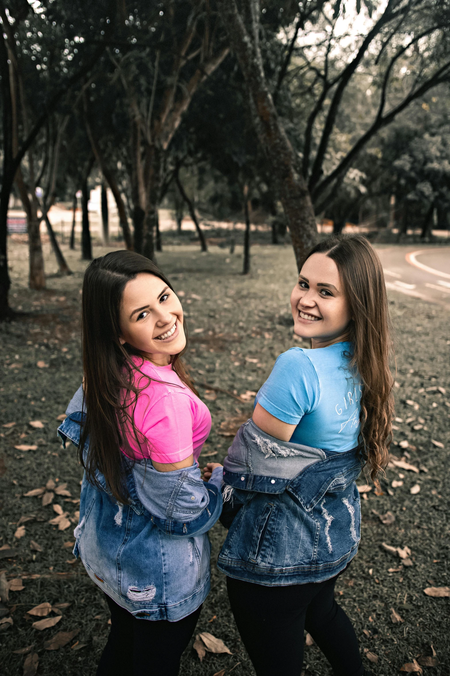 two girls standing next to each other in a park, by Lucia Peka, pexels contest winner, wearing a jeans jackets, in sao paulo, avatar image, attractive photo