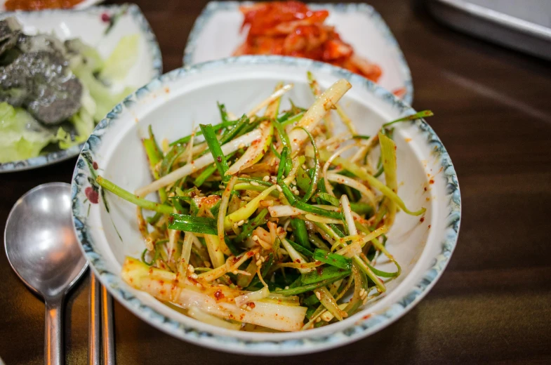 a close up of a bowl of food on a table, unsplash, mingei, pickles, square, stems, kwak ji young