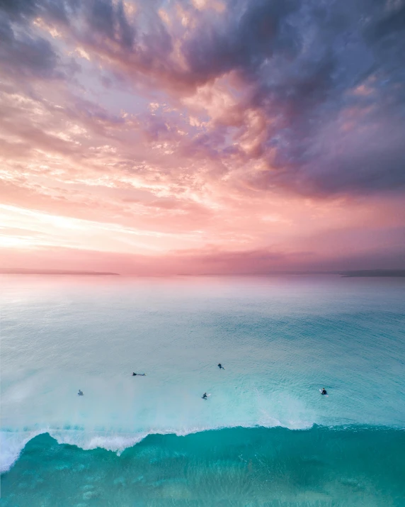 a group of people riding surfboards on top of a wave, by Seb McKinnon, unsplash contest winner, minimalism, pink clouds, calmly conversing 8k, bird's view, manly