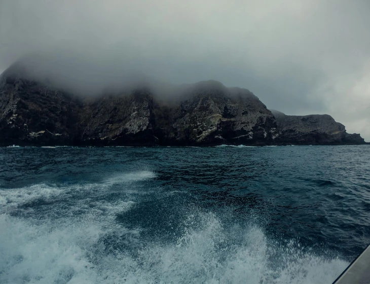 a large rock in the middle of a body of water, pexels contest winner, romanticism, raging sea foggy, photo taken from a boat, te pae, two medium sized islands