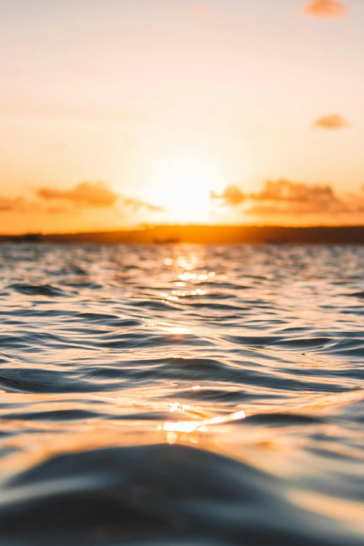 the sun is setting over a body of water, by Robbie Trevino, happening, shallow depth, golden hour 8k, big island, ripples