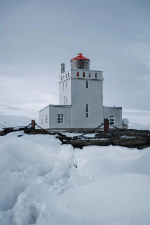 a lighthouse sitting on top of a snow covered hill, square, photographed for reuters, 8 k hi - res, iceland photography
