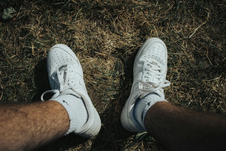 a pair of white sneakers sitting on top of a grass covered field, pexels contest winner, hyperrealism, wearing only pants, air force, hairy legs, white freckles