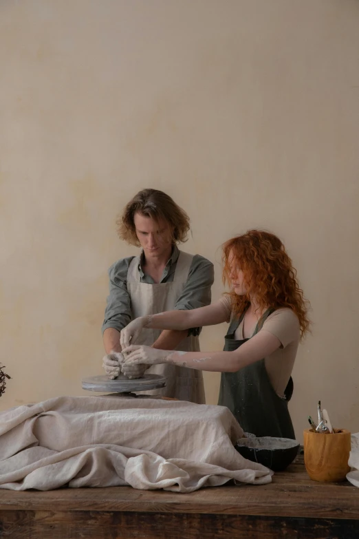 a couple of women sitting on top of a wooden table, hand built ceramics, over a dish and over a table, creating a soft, lachlan bailey