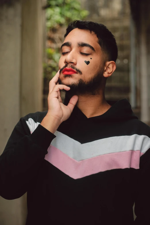 a man with his eyes closed talking on a cell phone, by Cosmo Alexander, trending on pexels, non binary model, zayn malik, lipstick, pointed hoods