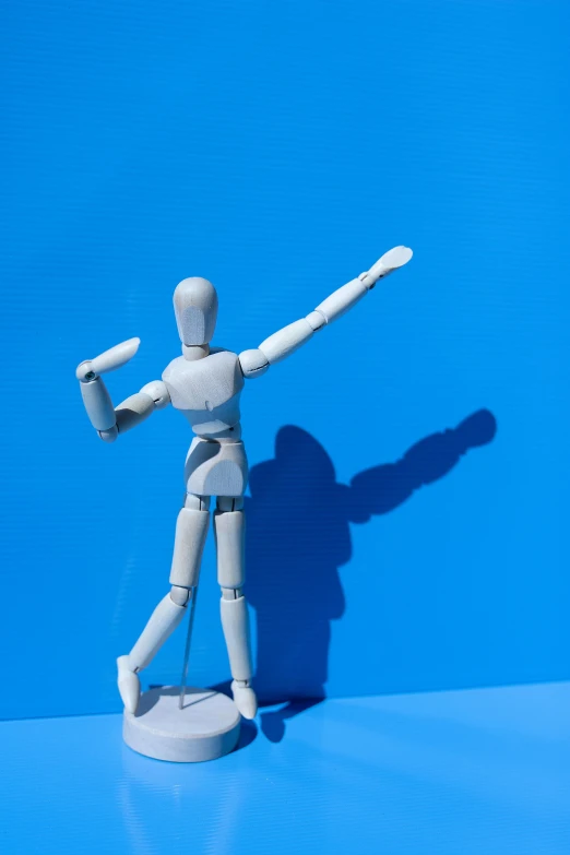 a wooden mannequin standing on a blue surface, dancing a jig, 15081959 21121991 01012000 4k, actionfigure, long shadow