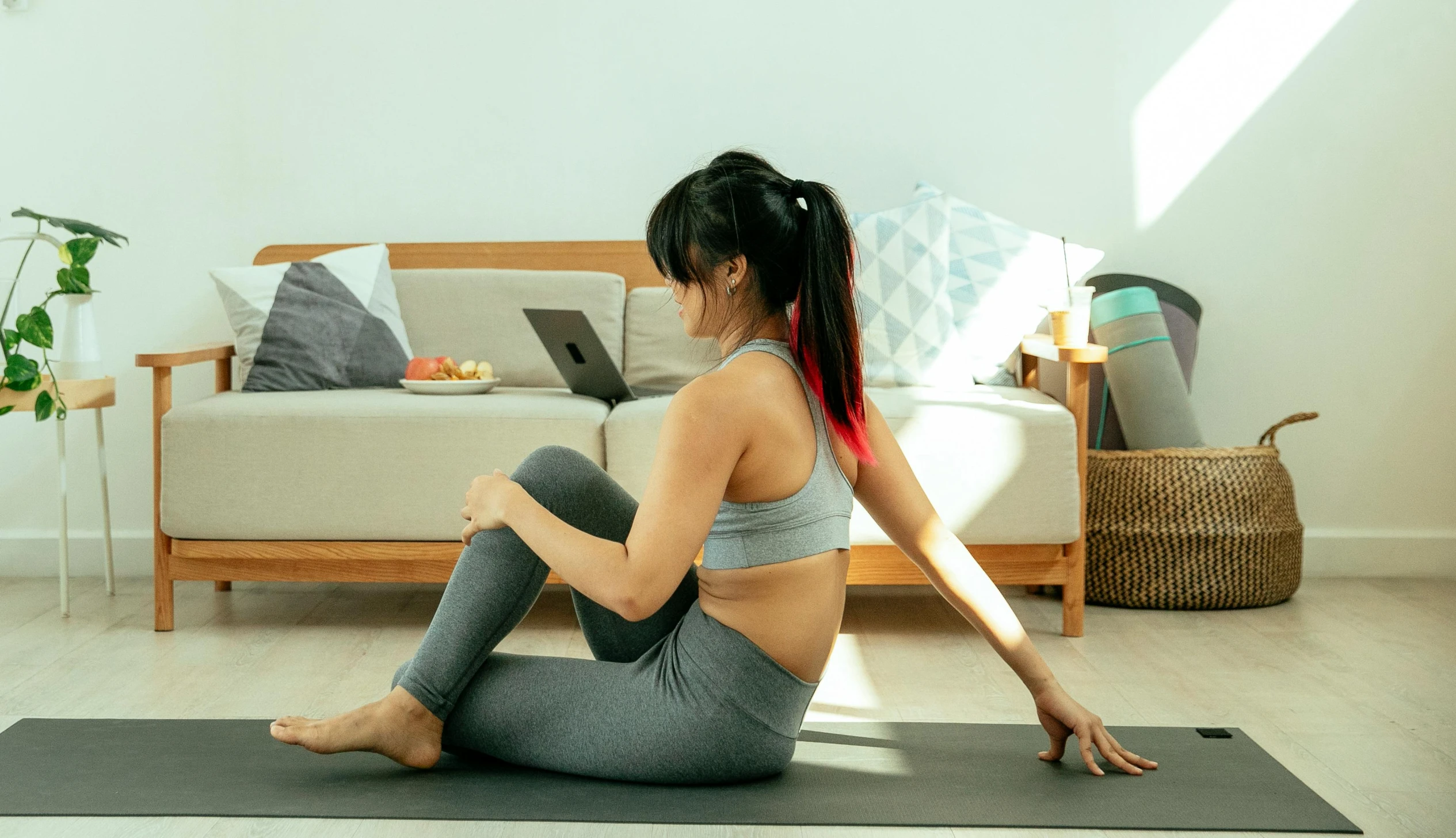 a woman sitting on a yoga mat in a living room, pexels contest winner, waist reaching ponytail, everything fits on the screen, looking partly to the left, gorecore