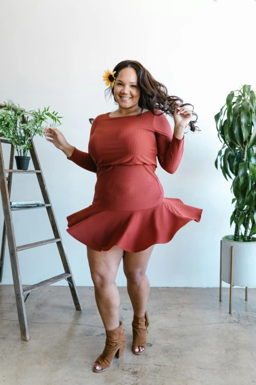 a woman in a red dress standing next to a ladder, wearing honey - themed miniskirt, twirls and curves, terracotta, full product shot