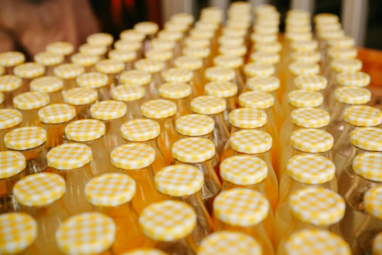 a table topped with bottles filled with orange juice, by Jessie Algie, pexels, patterned, in rows, yellow, thumbnail